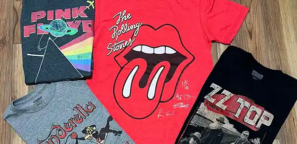 Wholesale band t-shirts on a wooden floor background.