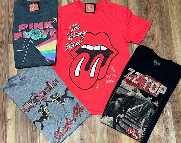 Wholesale band t-shirts on a wooden floor background.